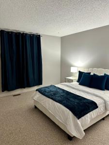 a bedroom with a large bed with blue pillows at Cozy private room in Edmonton in Edmonton