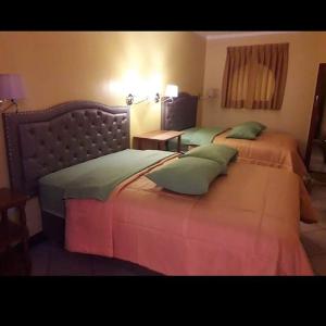 a hotel room with two beds and a table at Hotel karol in Ayacucho