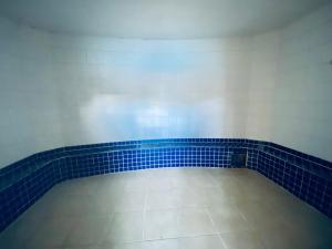 uma casa de banho com azulejos azuis nas paredes e piso enferrujado em Enseada Nautico Residence DE PAULA em Caldas Novas