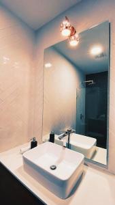 a bathroom with a white sink and a mirror at Deluxe Apto Guatemala zona 10 Edificio EON in Guatemala