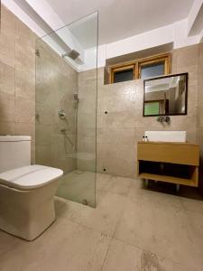 a bathroom with a shower and a toilet and a sink at Hotel Ladakh Greens in Leh