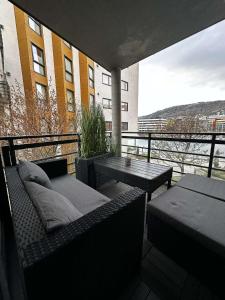 a balcony with benches and a table and a building at Nydelige Damsgårdsveien, 3-roms moderne leilighet! in Bergen