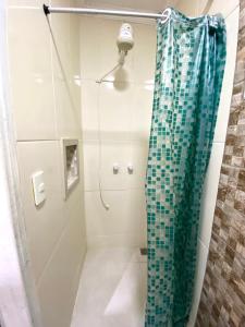 a shower with a glass shower curtain in a bathroom at Pousada Recanto Beach House - Cabo Frio - Unamar in Tamoios