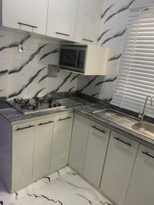 a kitchen with a counter top with a microwave at 2 bedroom flat Apartment in Ibadan