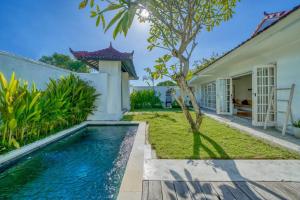una piscina en el patio trasero de una casa en Villa Olatu Berawa, en Canggu
