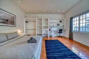 ein Wohnzimmer mit einem Bett, einem Schreibtisch und einem Tisch in der Unterkunft Villa Olatu Berawa in Canggu