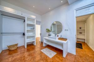 Un baño con un lavabo blanco y un espejo. en Villa Olatu Berawa, en Canggu 18 fotos más