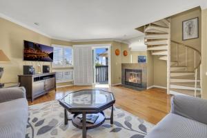 a living room with a staircase and a fireplace at Pine Street #2 in Oceanside