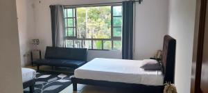 um quarto com uma cama, uma cadeira e uma janela em La Maison BLEUE em Cancún