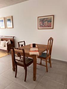 a wooden table and chairs in a living room at Departamento Lombardo in Lobos