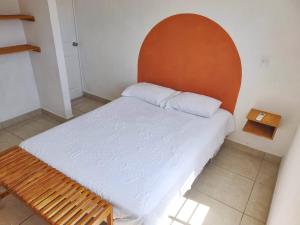 Bett mit orangefarbenem Kopfteil in einem Zimmer in der Unterkunft Casa Azur- vista al mar y alberca in Acapulco