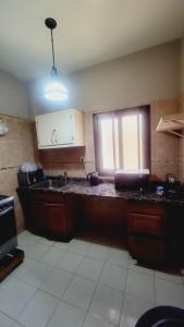 eine Küche mit einer Theke, einem Waschbecken und einem Fenster in der Unterkunft APPARTEMENT 2chambres salon ouest foire en bordure de la route in Dakar