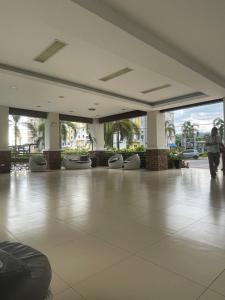 een grote lobby met een grote tegelvloer en ramen bij Spatial 8 condo in Davao City