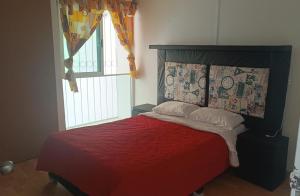 een slaapkamer met een rood bed en een raam bij Casa Boulevard in Mexico-Stad