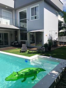 - une séance d'une tortue dans une piscine en face d'une maison dans l'établissement Casa Luxo com piscina a 500 metros da praia, à Florianópolis