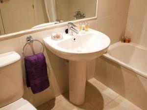 a bathroom with a sink and a toilet and a tub at Apartamentos Amatista Unitursa in Calpe