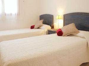 1 dormitorio con 2 camas con almohadas rojas. en Apartamentos Amatista Unitursa, en Calpe
