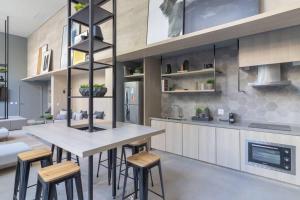 a kitchen with a large table and stools at Studio Campo Belo II in Sao Paulo