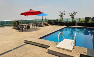 a pool with a table and chairs and an umbrella at GS Cuernavaca in Cuernavaca