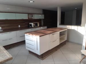 una cucina con mobili bianchi e un piano di lavoro in legno di trabalho ou lazer a Marília