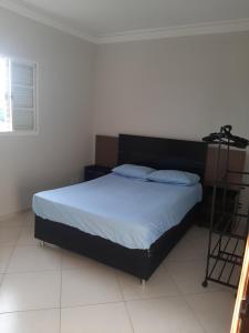una camera con letto e testiera nera di trabalho ou lazer a Marília