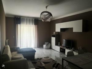 un soggiorno con un divano e una TV di Etna Holiday Apartment - Casa Vacanze a Fiumefreddo di Sicilia