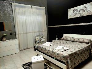 1 dormitorio con 1 cama y 1 silla en Etna Holiday Apartment - Casa Vacanze en Fiumefreddo di Sicilia