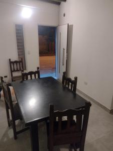 ein Esszimmer mit einem schwarzen Tisch und Stühlen in der Unterkunft Dpto Lgolf club cerca de Estadio único in Santiago del Estero