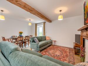 sala de estar con sofá y mesa en Grooms Cottage, en Westbury on Severn