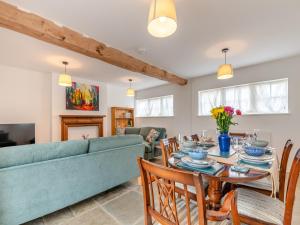 sala de estar con sofá, mesa y sillas en Grooms Cottage, en Westbury on Severn