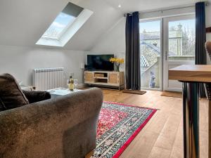 a living room with a couch and a tv at The Apartment - Uk47181 in Blaenporth