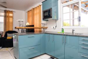 a kitchen with blue cabinets and a sink at Fare Piafau - Aéroport Faa'a Tahiti in Faaa