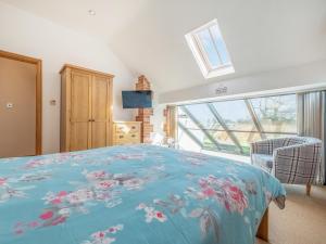 a bedroom with a bed with a blue comforter at The Great North Barn - Ukc2526 in Trunch