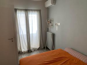 ein Schlafzimmer mit einem orangenen Bett und einem Fenster in der Unterkunft Lovely luxurious apartment in Athen