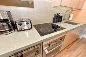 a kitchen counter with a stove and a sink at 300 Front Suites in Toronto