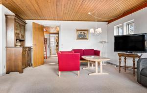 uma sala de estar com cadeiras vermelhas e uma televisão em 4 Bedroom Gorgeous Home In Skagen em Skagen