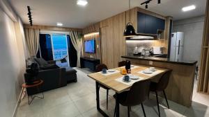 a kitchen and living room with a table and chairs at Studio 1304 Estilo e bem-estar no Cariri in Juazeiro do Norte