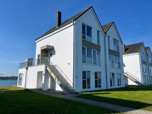 a large white building with stairs on the side of it at Ferienwohnung Schlei & Meer Olpenitz in Olpenitz