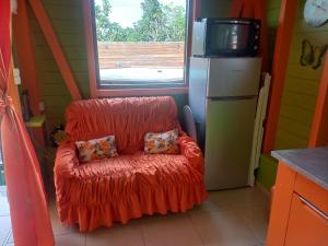 - un fauteuil rouge avec deux oreillers dans la cuisine dans l'établissement Fatou location, à Petit-Bourg