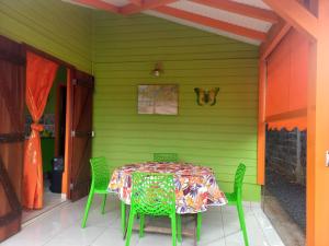 une maison verte avec une table et des chaises dans l'établissement Fatou location, à Petit-Bourg