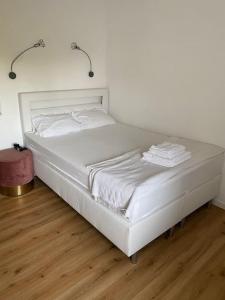 uma cama branca num quarto com piso em madeira em Schöne, kleine, gemütliche Wohnung - Stadtmitte em Mainz