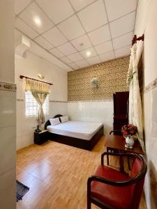 ein Schlafzimmer mit einem Bett und einem Schreibtisch in einem Zimmer in der Unterkunft Khách sạn Nam Đô 2 in Cần Thơ