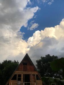 a wooden house with a cloudy sky in the background at Cabañas Refugio verde in El Soberbio