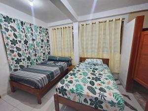 ein Schlafzimmer mit einem Bett, einem Sofa und Vorhängen in der Unterkunft Hostal Beru in Puerto Nariño