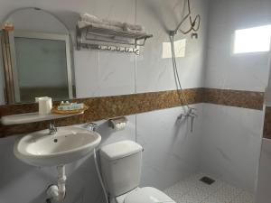 bagno con servizi igienici bianchi e lavandino di Du Hung 1 Hotel a Hà Tiên