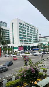 duży budynek z samochodami zaparkowanymi na parkingu w obiekcie AizatAzmi Homestay w Malakce +15 zdjęć