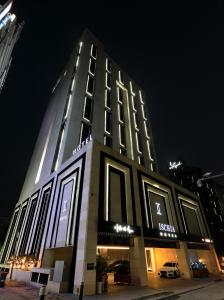 un palazzo alto con luci accese di notte di Hotel Ischia a Yongin
