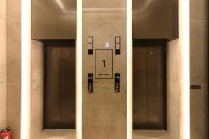 una fila di quattro porte dell'ascensore in un edificio di Hotel Ischia a Yongin