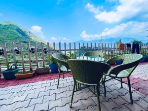 patio con sedie, tavolo e recinzione di Krishma Guest House a Rajkot