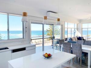 a kitchen and living room with a view of the ocean at Blue Pacific Apartment 8 in The Entrance